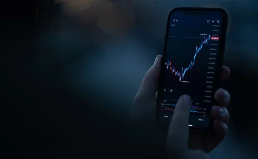 person holding mobile device viewing stock chart